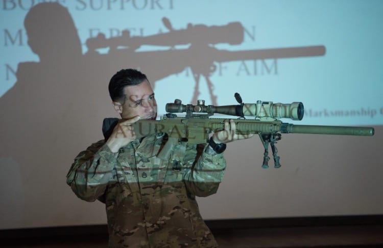 Holding sniper rifle teaching a class
